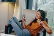 © SHOTPRIME STUDIO - Young woman enjoying snacks and watching a movie on her smartphone, dressed in casual attire, with a cozy interior and natural light, reflecting a relaxed lifestyle
