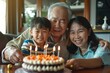 © Anjali - happy three generation asian family celebrating grandpas birthday at home