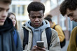 © tynza - A close-up of a student receiving mean messages on their phone during a break at school.
