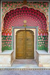 Traditional Rajasthani door adorned in vibrant yellow hues, showcased at the City Palace in Jaipur.