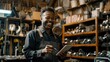© jureephorn - A professional salesman in a hardware warehouse, smiling warmly as he checks supplies on his tablet, with shelves of tools and equipment in the background
