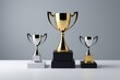 © haiqiang - three trophies on a table with a gray background