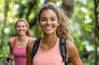 © HQAsset - Smiling woman hiker in nature, enjoying a trek with a friend in lush greenery.