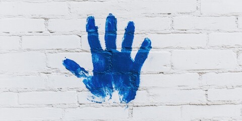 Wall Mural - a bold blue handprint stands out against a textured white brick wall in this artwork