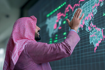 Wall Mural - Arab businessman interacts with a global financial data screen, analyzing market trends and investment opportunities.