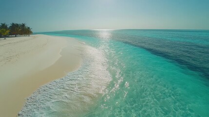 Wall Mural - A serene beach view with soft waves and clear turquoise water under bright sunlight, creating a perfect tropical escape for relaxation and enjoyment.