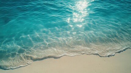 Wall Mural - Serene Blue Ocean Waves Lapping Gently on Soft Sandy Beach Under a Bright Sun, Perfect for Relaxation and Peaceful Escapes in a Tropical Paradise.