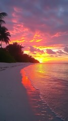 Wall Mural - A stunning sunset over the calm ocean with vibrant colors reflected on the water. Palm trees frame the beautiful beach scene under a colorful sky.