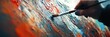 © milenialdesastudio - Close-up of an artist's hand painting on a canvas with vibrant colors and thick paint texture.