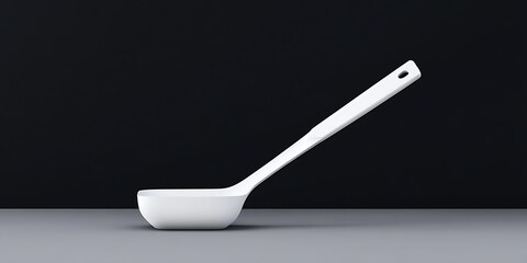 a simple white ladle resting on a surface against a dark background.