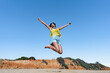 © Juan Pedro Peña - Mujer saltando de alegría porque es una ganadora, un sensacional día de vacaciones en la playa, soleado con cielo azul