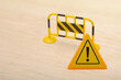 © TeacherPhoto - The construction barrier and the warning sign together symbolize a potential hazard or danger zone.
