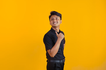 Satisfied man with thumbs up on yellow background