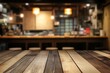 © anak - Empty wooden table in front of blurred restaurant background.