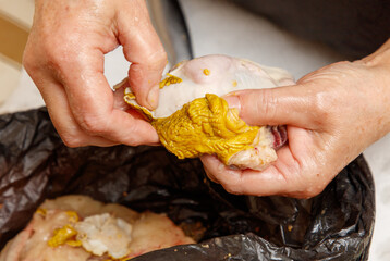 Wall Mural - A person is holding a piece of meat that has been coated in mustard