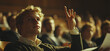 © Rastika - Young man raising his hand to ask a question in a lecture hall.