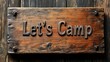 © Wiryo - Rustic wooden sign that says 'Let's Camp'.