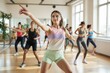 © PlanetOfVectors - Women performing dance moves in a fitness class inside a brightly lit studio with wooden flooring and plants. Concept of group dance exercise. Ai generative