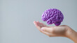 © Teeradej - Purple day for epilepsy awareness concept. hand holding purple brain model against plain background