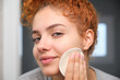 © Cavan Images - Young woman cleaning her face with a reusable makeup remover pad