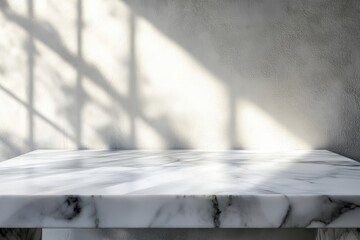 Wall Mural - White marble table top with sunlit shadows on a grey wall background.