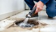 © Ali Hamza Tullah - Plumber unclogging blocked shower drain with hydro jetting at home bathroom. sewer cleaning service