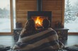 © Liza - A couple enjoys the warmth of a fireplace in a cozy winter cabin.