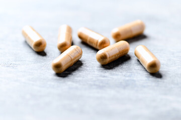 Wall Mural - Korean Ginseng capsules. Concept for a healthy dietary supplementation. Wooden background. Soft focus. Close up.