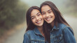 © roei - Identical twin women wearing casual denim jackets smiling against natural backdrop cheerful portrait