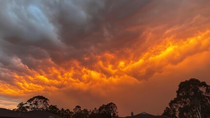 Aufkleber - A dramatic sunset with vibrant orange hues against dark clouds.