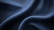 © BerkahStock - Close-up of elegant, dark blue fabric with soft, flowing drapes and subtle texture.