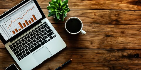 Wall Mural - A top-down perspective of a wooden desk featuring a laptop displaying analytical graphs, a cup of black coffee, a small green succulent, and a pen
