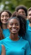 © BrightWhite - Smiling biracial girl leads diverse group of volunteers in blue shirts