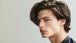 © Wiryo - Close-up portrait of a young man with long, styled hair, looking over his shoulder.