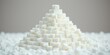 © Vibrant Visions Pixe - A pyramid of refined sugar cubes rests on a bed of granulated sugar, a visual representation of excess and potential health concerns.