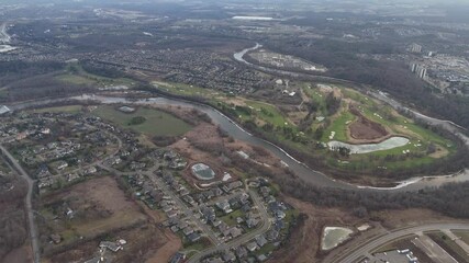 Wall Mural - Aerial view of buildings with winding river, golf course and green spaces in Canada