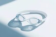 © Alex - refined studio composition of pair of sleek swimming goggles resting on bright white surface