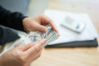 © boyloso - Cropped shot view of someone counting American dollar banknotes. The US Dollar is the currency of United States.