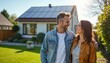 © schiers_images - Joyful couple embracing in front of a house equipped with solar panels, showcasing sustainable actions and green living.
