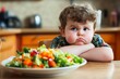 © Michael - An overweight child sits unhappily in front of a salad.