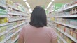 © Duskcraft - Woman Walking Through Grocery Store Aisle Surrounded by Various Food Products