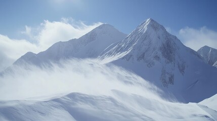 Majestic snow-covered mountain peaks with strong winds creating a dramatic snow drift under a clear blue sky.