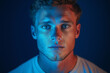 © mhdws - Captivating portrait of a young man with blue lighting studio photography dramatic close-up