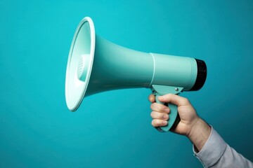 A hand holds a blue megaphone against a bright blue backdrop.