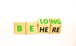 © Dzmitry - Belonging and belong symbol. Concept words Be here Belong on beautiful wooden block. Beautiful white table white background. Business motivational belonging and belong concept. Copy space.