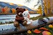 © starmukti - Lonely brown teddy bear hugs fluffy stuffed toy bunny sitting on fallen birch tree trunk near tranquil river on autumn day backside view