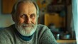 © AbstractAI - Cheerful elderly man with a beard smiling at home in a cozy workspace warm lighting close up portrait of a senior human connection
