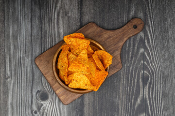 Wall Mural - Nachos in a wooden bowl. Tortilla chips on wooden background.