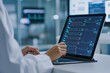 © Peter@studio5 - A healthcare professional analyzes patient data on a tablet, surrounded by medical equipment in a clinical setting.