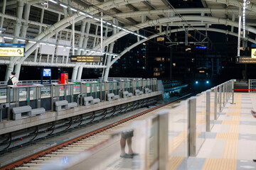 a modern metro train at a station in Ho Chi Minh City, Vietnam. The train features a sleek design with blue stripes, a clean platform, and glass barrier